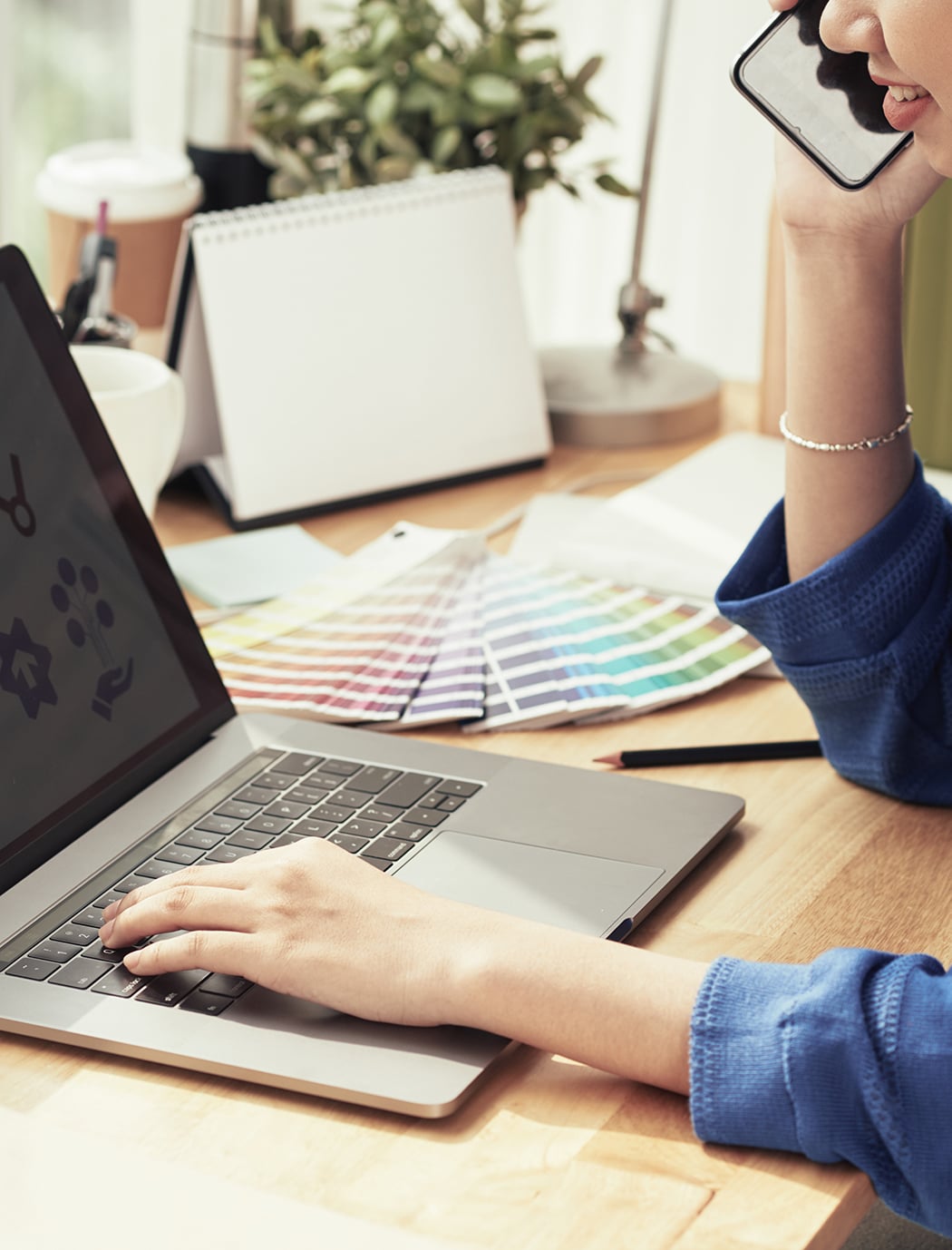 スマホで電話をしながらパソコンをしている人物